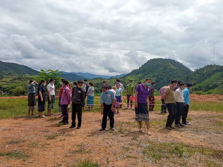 Workshop participants play the “pen in bottle” game to practise good teamwork